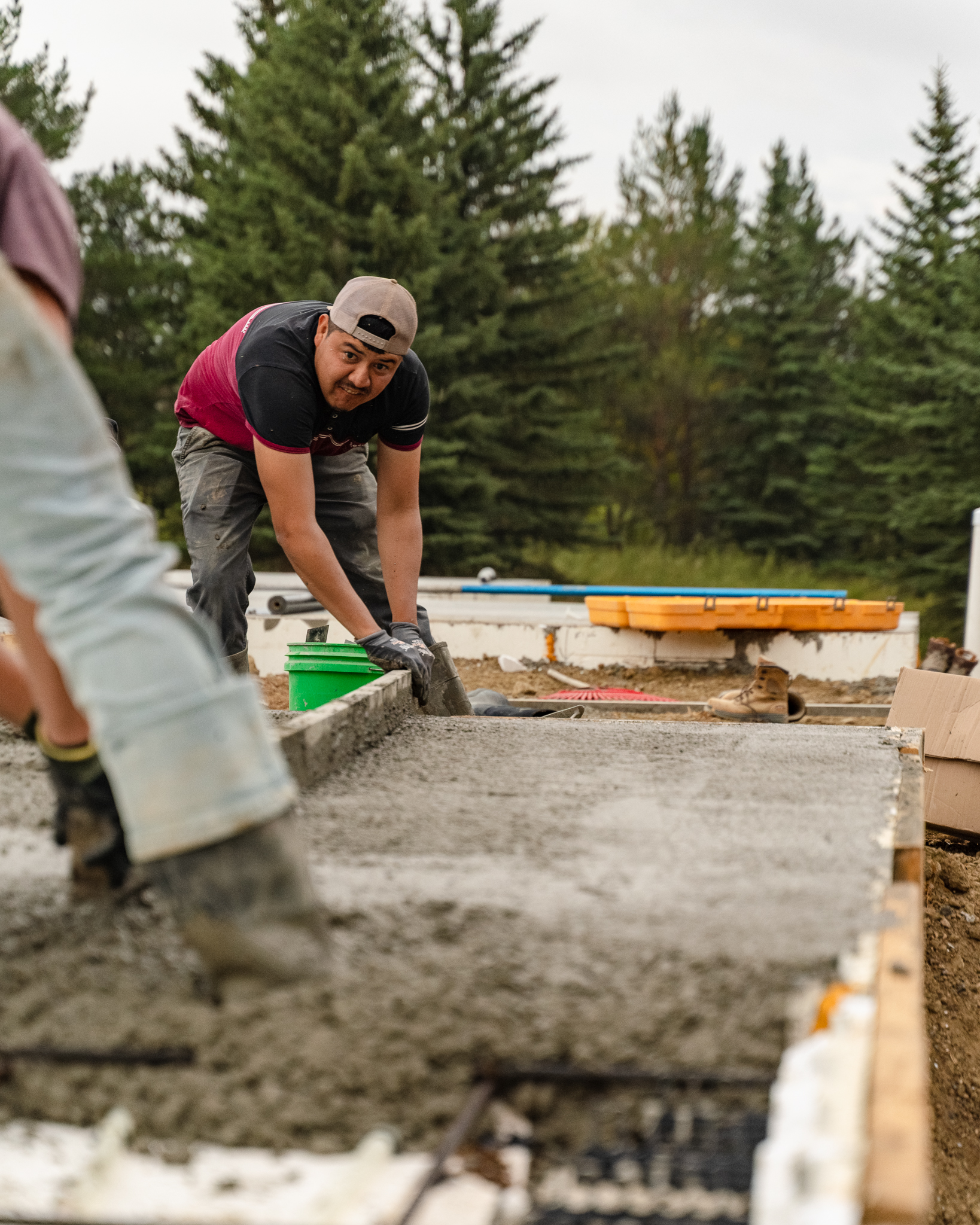 48 North Concrete crew member finishing a fresh concrete slab with hand tools