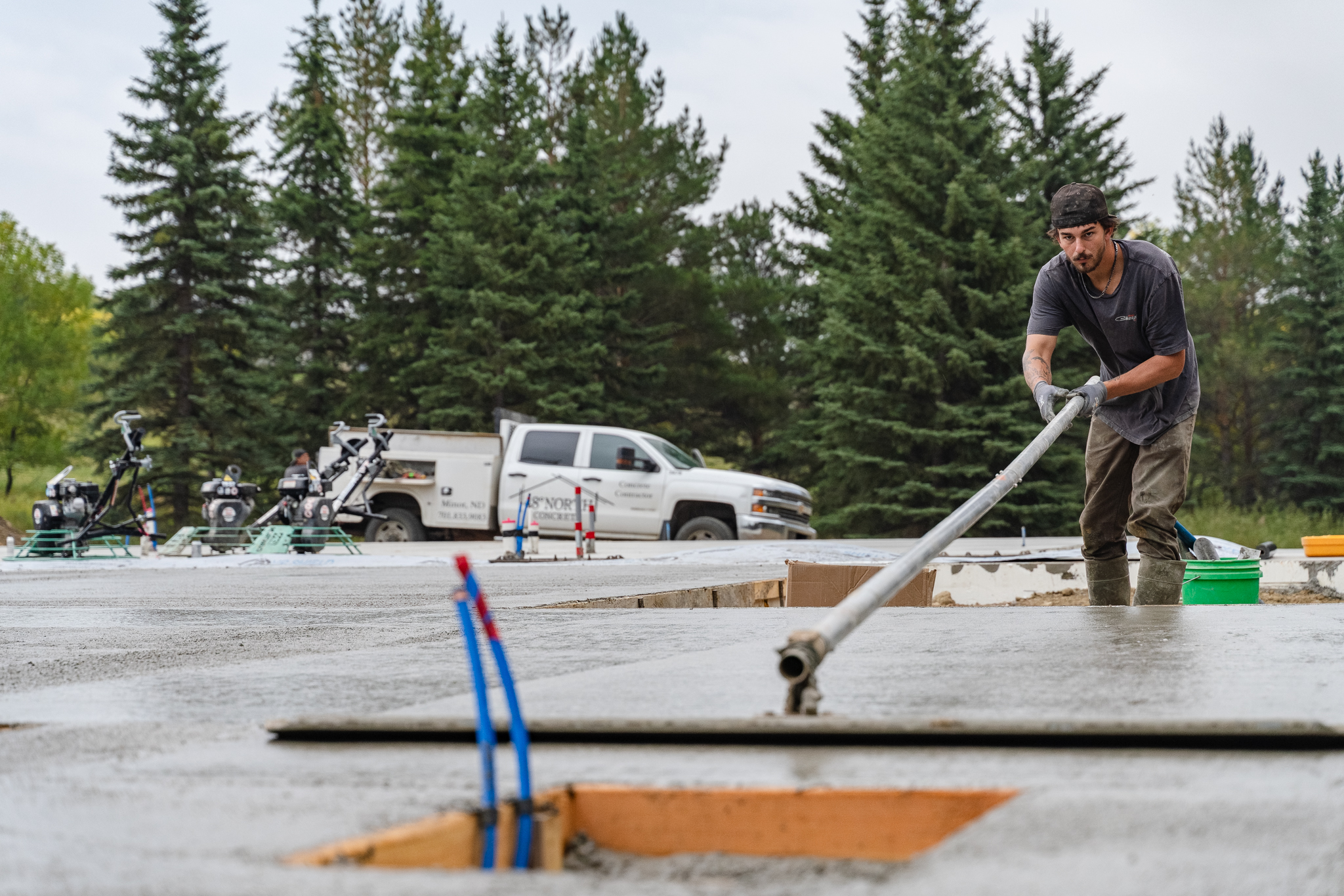 Worker screeding fresh concrete slab