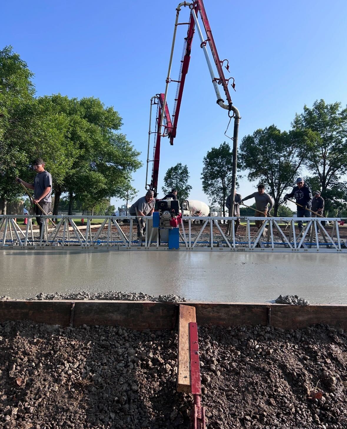 Crew operating truss screed on a large concrete pour in winter conditions